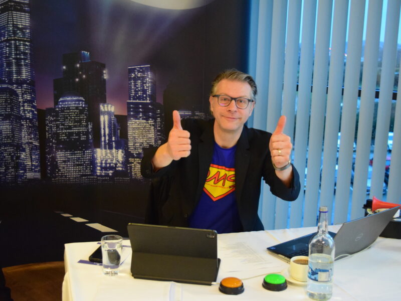 Greg Approval double thumbs up sat at desk