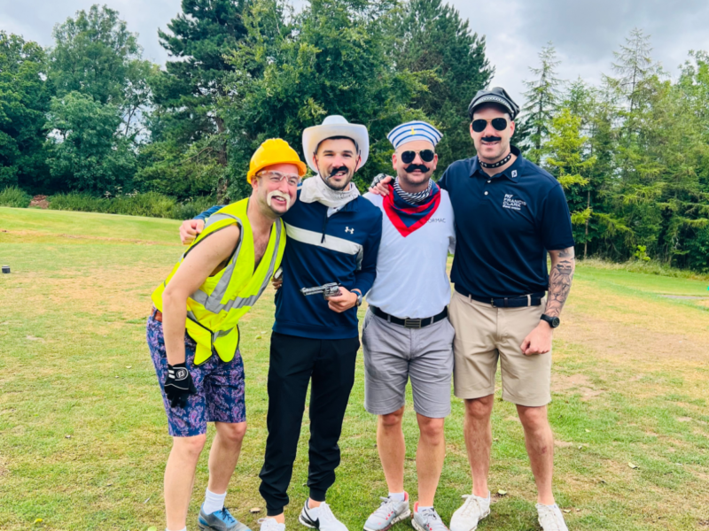 group of four in fancy dress playing golf