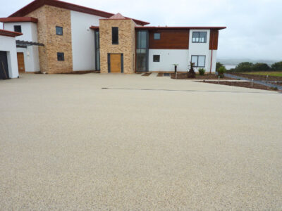 Residential property exterior with light brown resin bound driveway