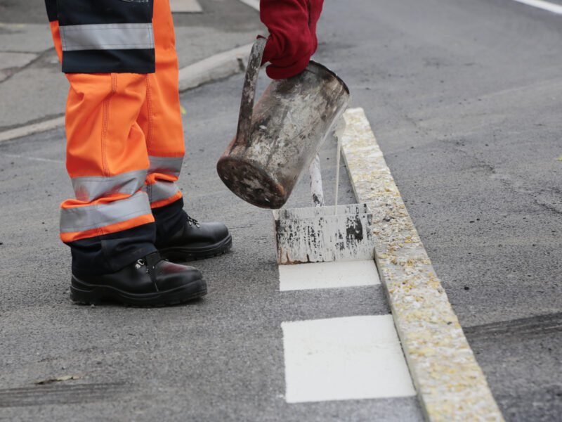 Close up of a QMS team member line painting at Kingkerswell bypass