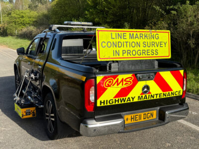 QMS car with sign - Line marking condition survey in progress