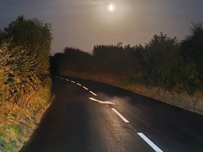 Freshly applied MMA centre line and directional arrow reflecting under headlights on a rural road at night