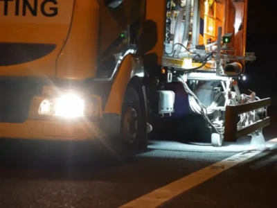 Road marking lorry applying a white MMA edge line to a carriageway during a night works closure
